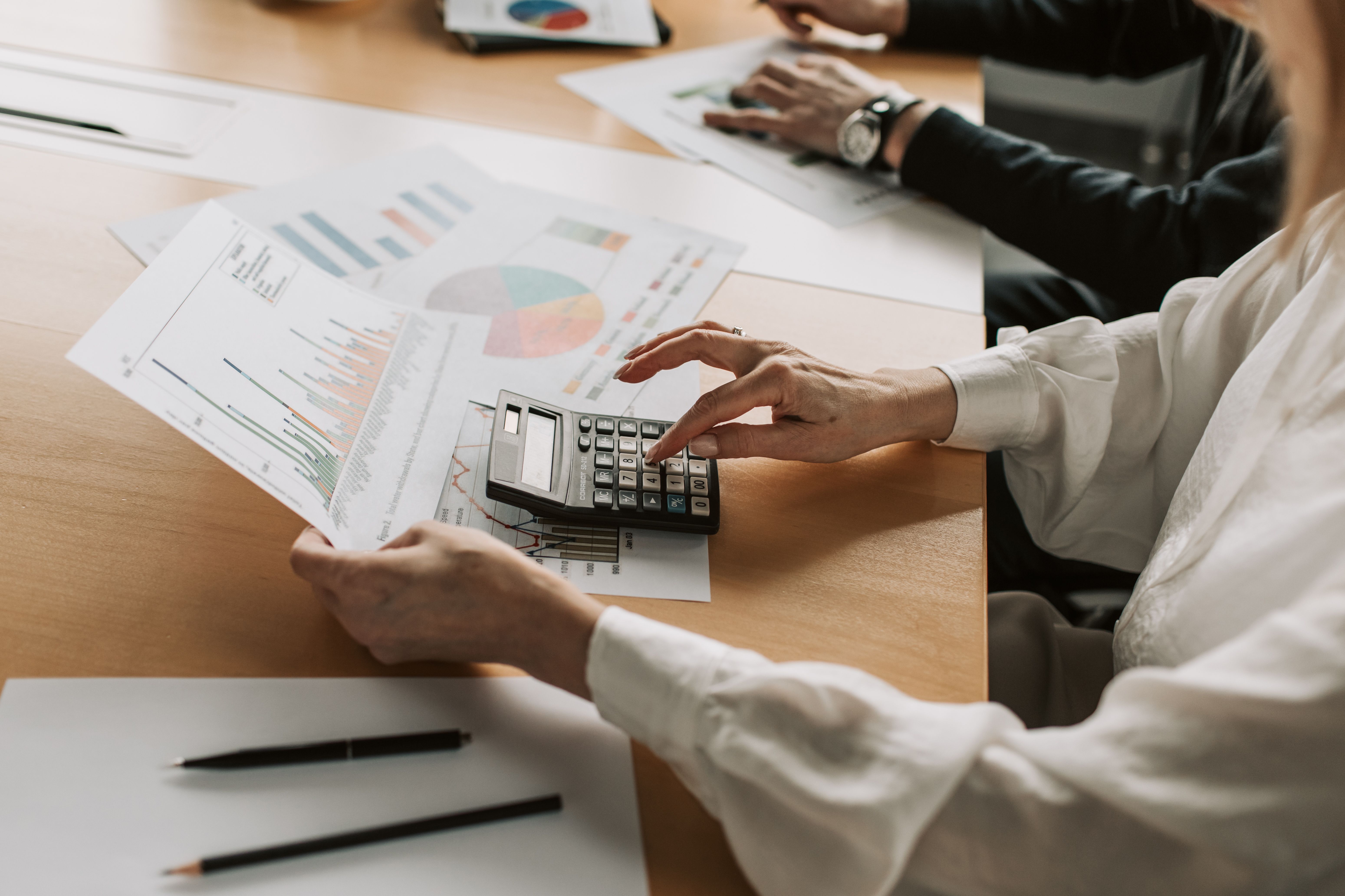 Hands reviewing printed financial charts at a meeting table