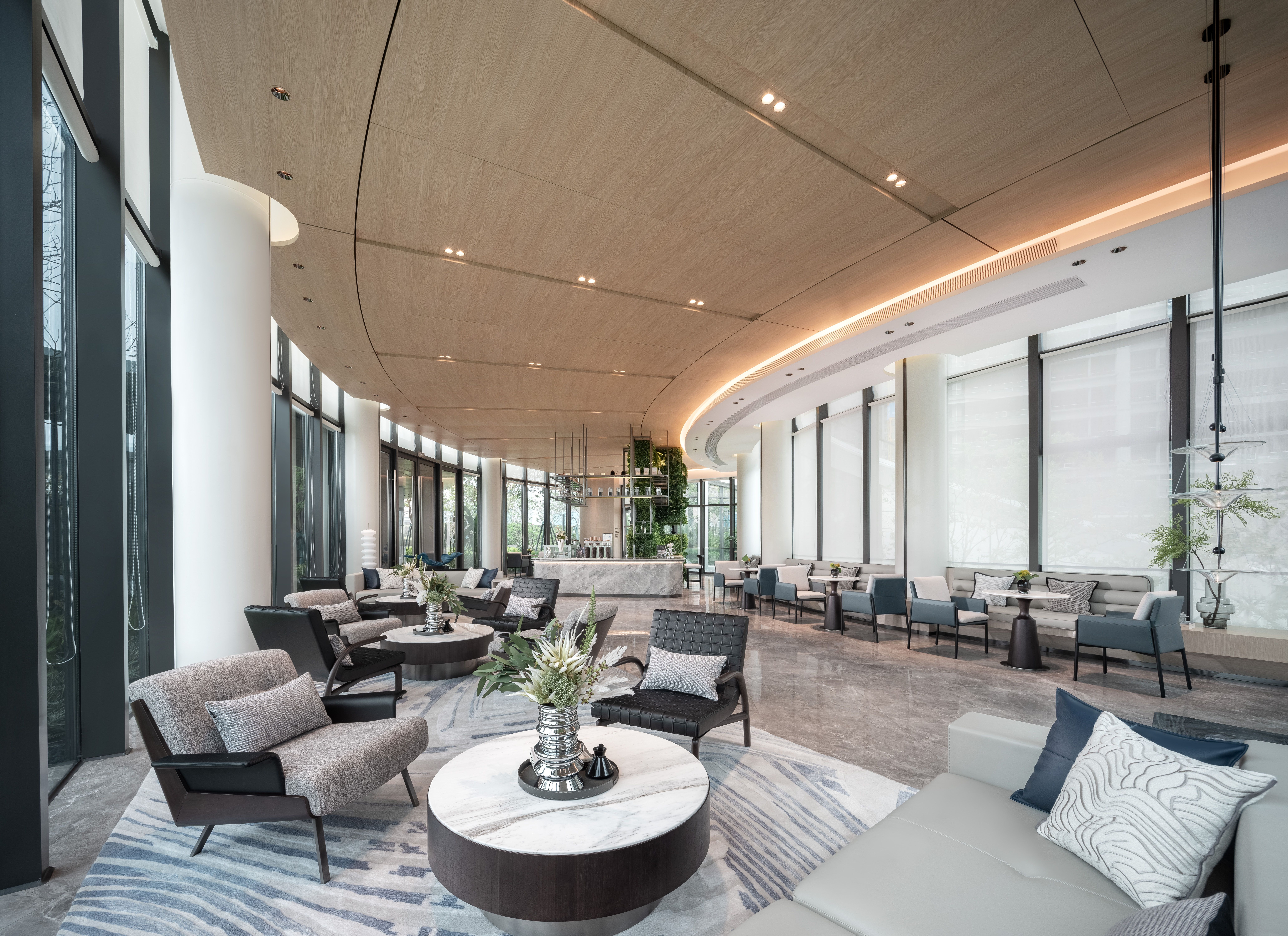 Contemporary luxury hotel lobby with curved timber ceiling, glazing and refined neutral seating